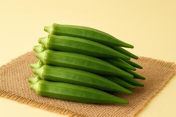 Fresh okra pods stacked on jute cloth